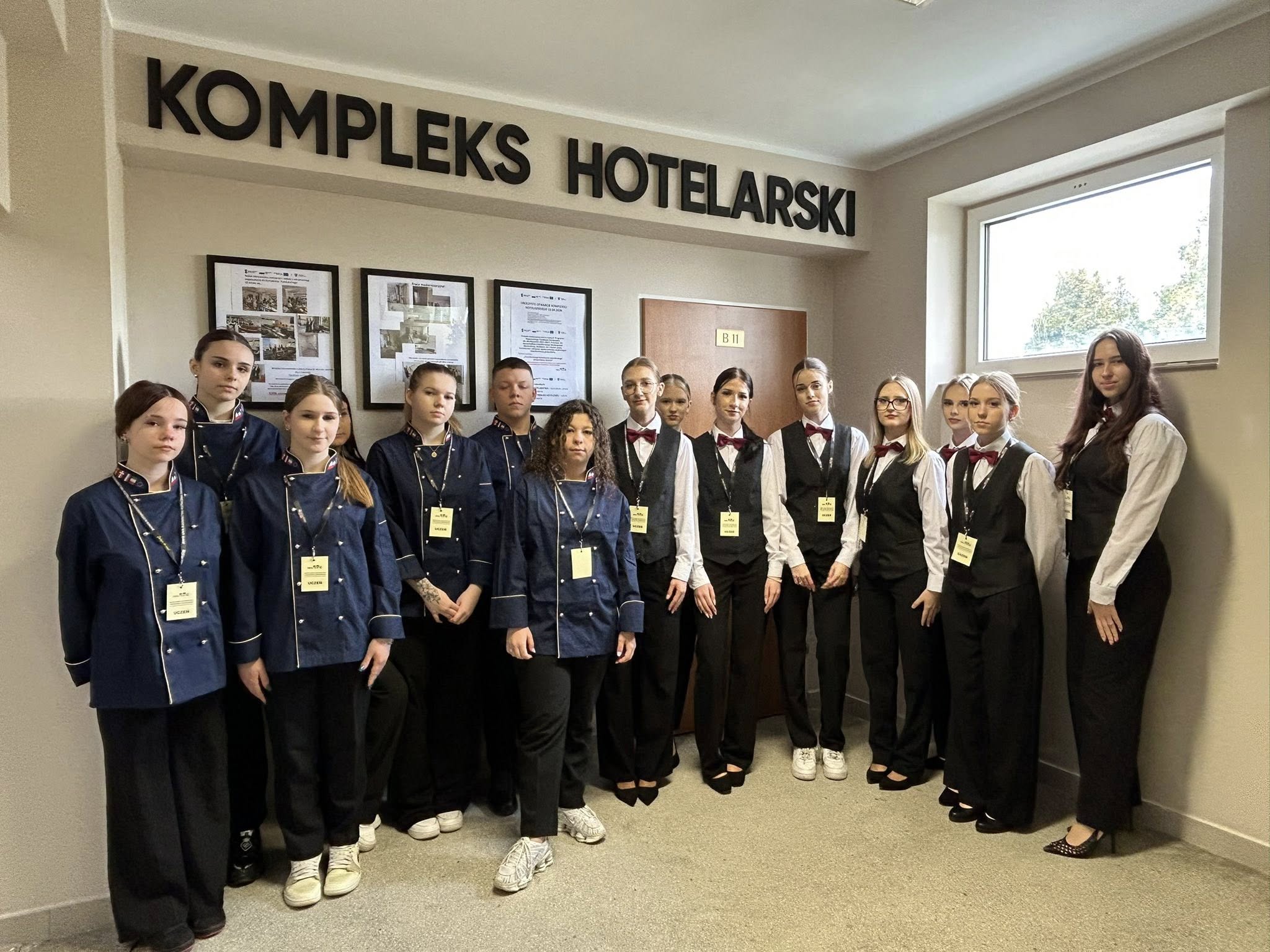 uczniowie stoją w szeregu pod napisem kompleks hotelarski